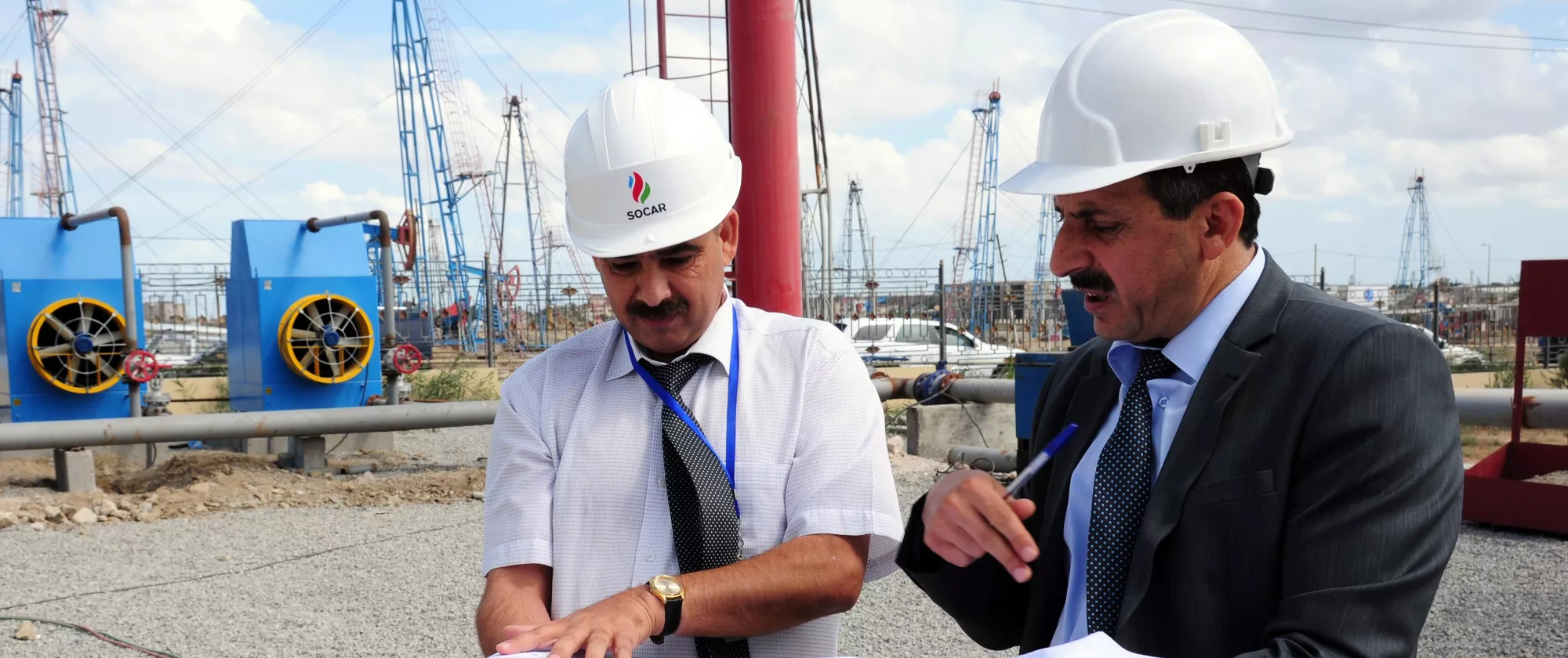 Azerbaijan country portal hero image two men discuss documents at a construction site