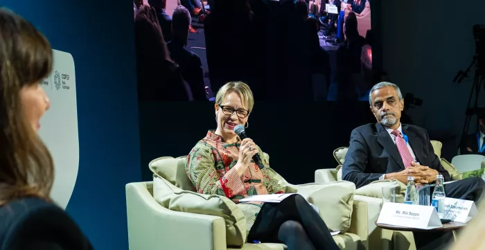 Men and women sitting on chairs holding microphones