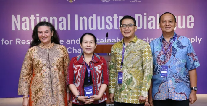 Four representatives of the ILO, trade union, Coordinating Ministry for Economic Affairs and Ministry of Manpower standing on the stage.